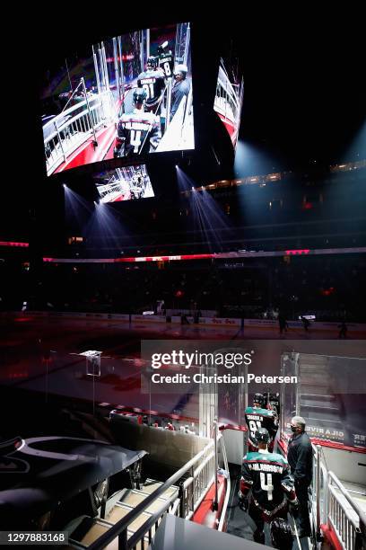 Drake Caggiula and Niklas Hjalmarsson of the Arizona Coyotes skate onto the ice with teammates before the NHL game against the Vegas Golden Knights...