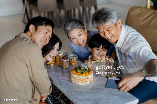 asian family taking a selfie photo during a birthday party at home - asian grandmother stock pictures, royalty-free photos & images