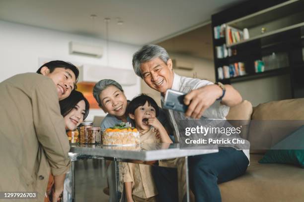 asian chinese family taking selfie on their son's birthday celebration - chinese family taking photo at home stock pictures, royalty-free photos & images