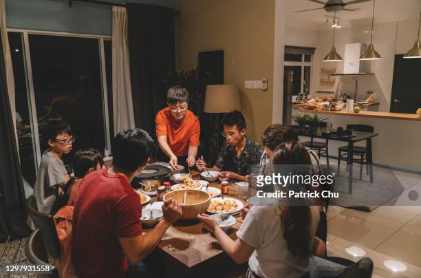 アジアの中国人家族といとこは自宅で同窓会の夕食を持っています - large family ストックフォトと画像