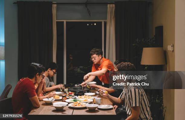 asiatische chinesische familie und cousins bei wiedersehen abendessen zu hause - familie zuhause essen stock-fotos und bilder