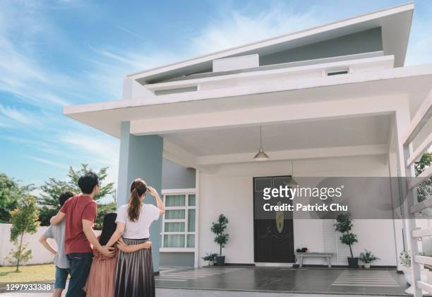 asian chinese family looking at their new house with their daughter and son - moving house stock pictures, royalty-free photos & images