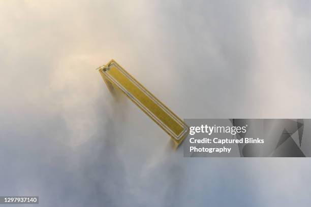 aerial top birds eye view of dubai frame covered in dense fog during winter at sunrise - dubai frame stockfoto's en -beelden