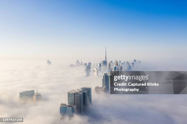 aerial view of dubai frame and skyline covered in dense fog during winter season - panorama dubai stock pictures, royalty-free photos & images