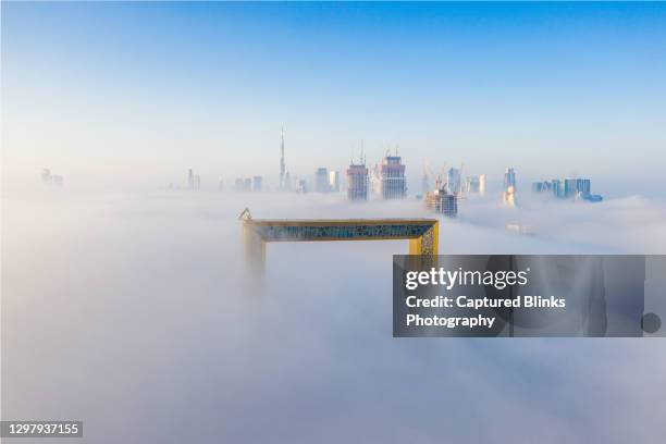 aerial view of dubai frame and skyline during fog in winter - dubai frame stockfoto's en -beelden