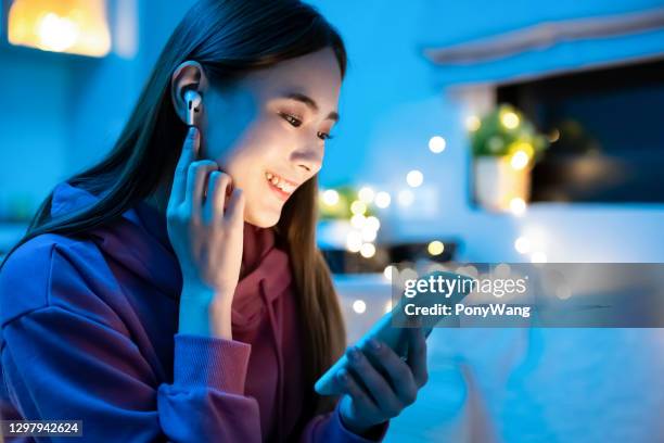 girl use phone listen music - in ear headphones stock pictures, royalty-free photos & images