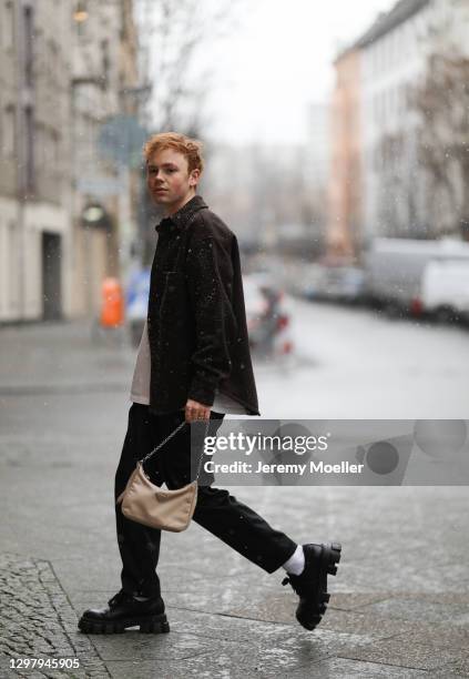 Erik Scholz wearing a Weekday khaki jacket, Jil Sander white shirt, Holzweiler black pants and Prada mokassins and beige bag on January 21, 2021 in...