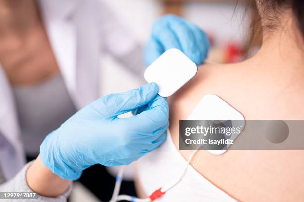 female physiotherapist is examining to her patient. - electrode stock pictures, royalty-free photos & images