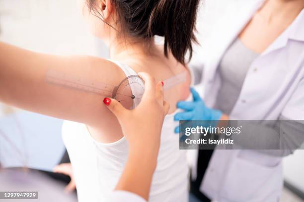 female physiotherapist is examining to her patient. - protractor stock pictures, royalty-free photos & images