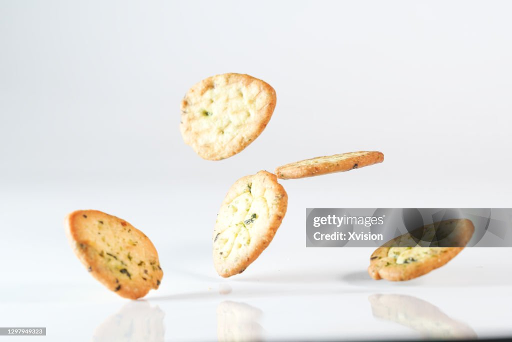 Vegetable biscuits flying in mid air in white background
