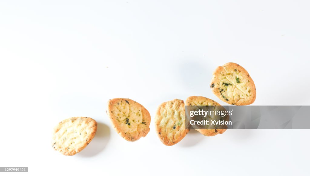 Vegetable biscuits flying in mid air in white background