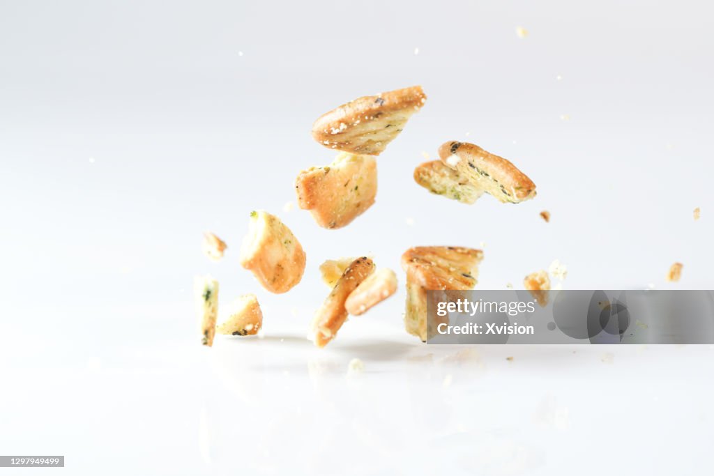 Vegetable biscuits flying in mid air in white background