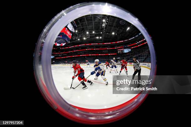 Lars Eller of the Washington Capitals skates past Henri Jokiharju of the Buffalo Sabres during the second period at Capital One Arena on January 22,...