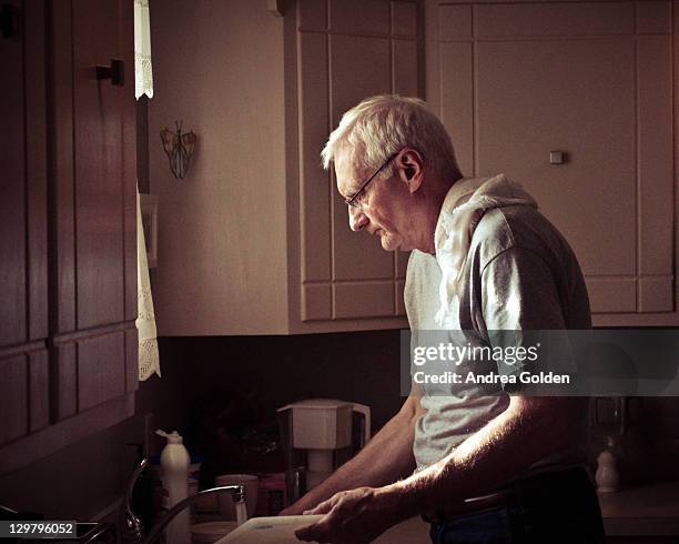 older man washing dishes - washing up stock pictures, royalty-free photos & images