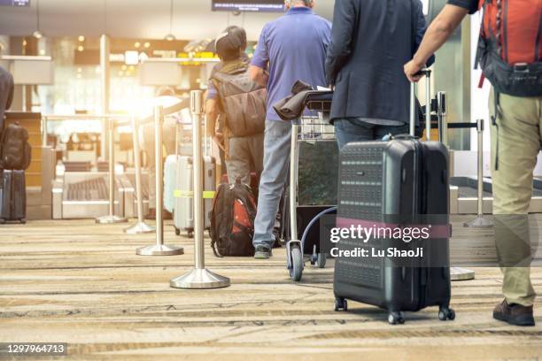 passengers lined up at the airport to check in their luggage. - partido internacional - fotografias e filmes do acervo