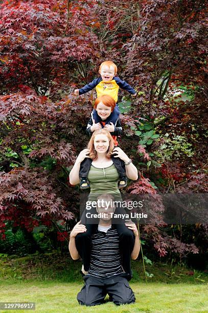 family totem pole - front view portrait of four children sitting on rock stock pictures, royalty-free photos & images