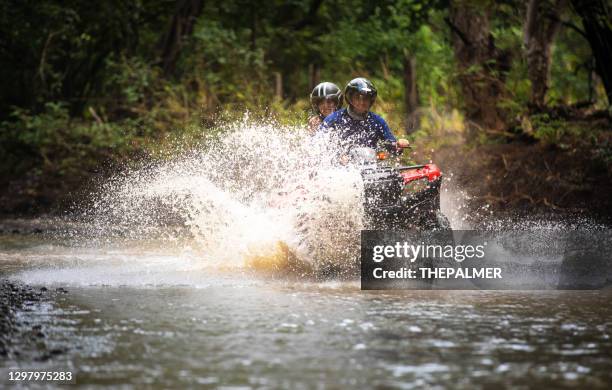 father and daughter driving quad bike in costa rica - off road vehicle stock pictures, royalty-free photos & images