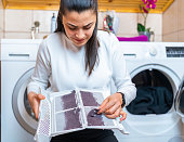 Young woman is removing lint from fluff dust filter of the tumble dryer. Dust and dirt trapped by the clothes dryer filter. Laundry processes