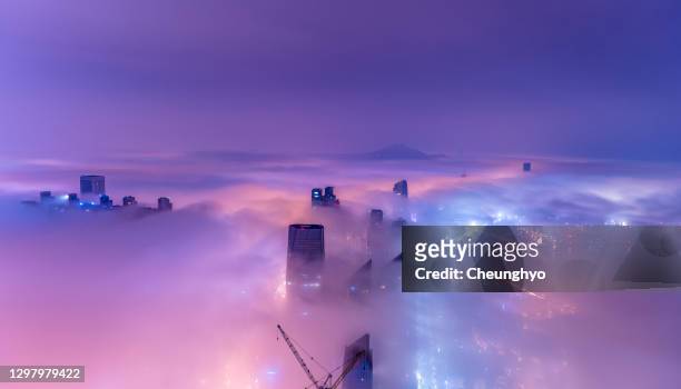 qingdao city in the mist at night - imponente fotografías e imágenes de stock