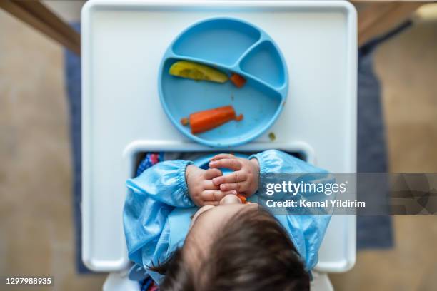 baby boy essen seine erste mahlzeit selbst - moments daily life from above stock-fotos und bilder