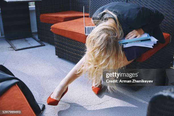 exhausted businesswoman resting on a pile of work files while wearing red pumps - business woman high heels stock pictures, royalty-free photos & images