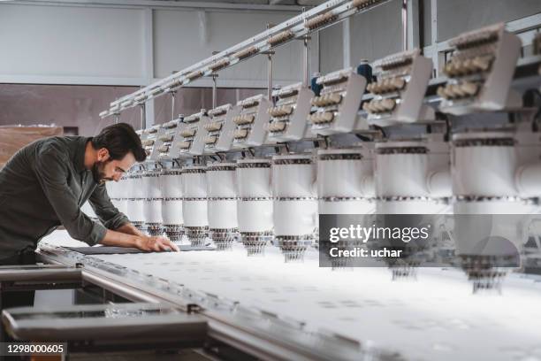 man working in textile embroidery machine - textile factory stock pictures, royalty-free photos & images