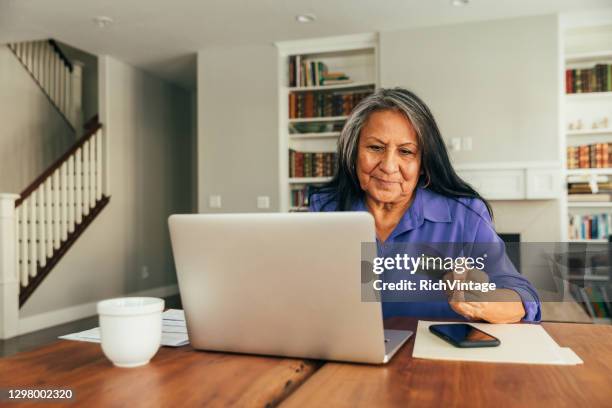 senior woman paying bills and banking online - aboriginal elders stock pictures, royalty-free photos & images