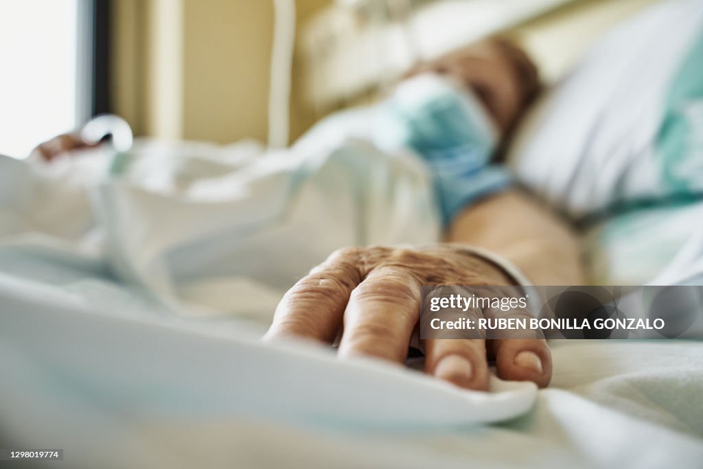 Senior woman wearing face mask lying on hospital bed