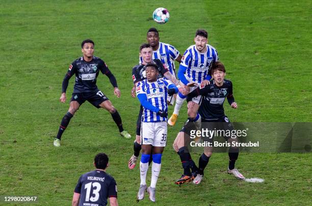 Marco Friedl of Werder Bremen jumps for a header with Daishawn Redan of Hertha BSC and Jhon Cordoba of Hertha BSC during the Bundesliga match between...