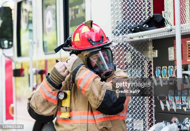 firefighter in fire protection suit and respirator mask - firefighter getting dressed stock pictures, royalty-free photos & images