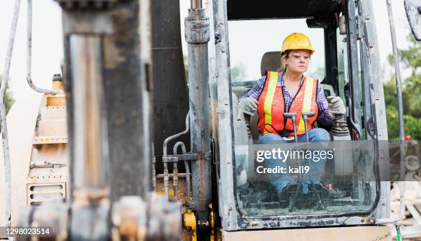 ouvrier hispanique de construction conduisant le déménageur de terre - équipement de construction photos et images de collection