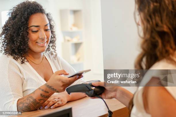 two women in a shoes store. contactless payment - vendor payment stock pictures, royalty-free photos & images