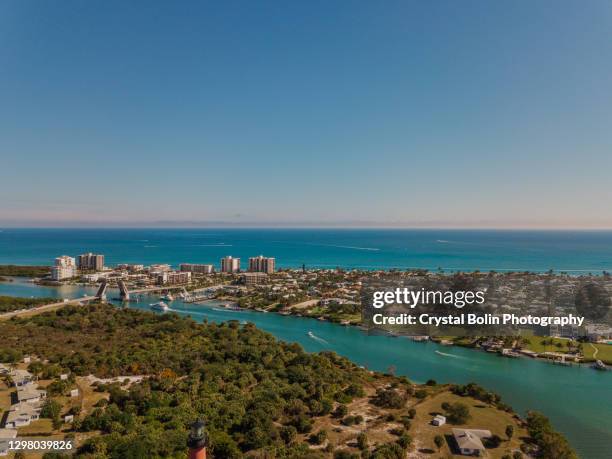 weekend aerial views of boats moving on the teal ocean water & the jupiter lighthouse in jupiter beach, florida at mid-day in january of 2021 - jupiter florida stock pictures, royalty-free photos & images