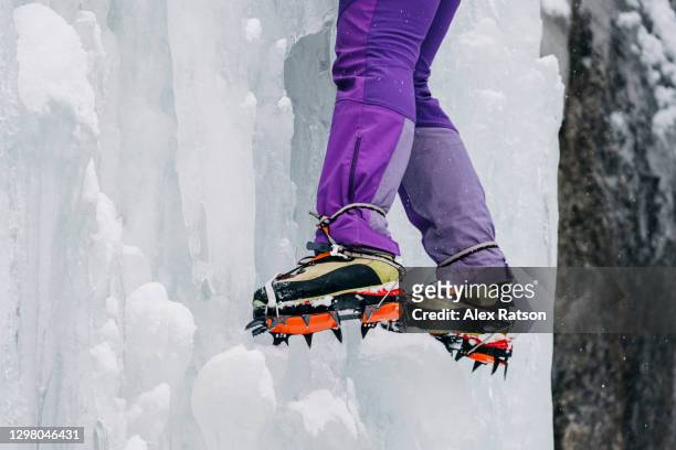 close up shot of female ice climbers crampons kicked into a wall of vertical ice - pointed foot stock pictures, royalty-free photos & images