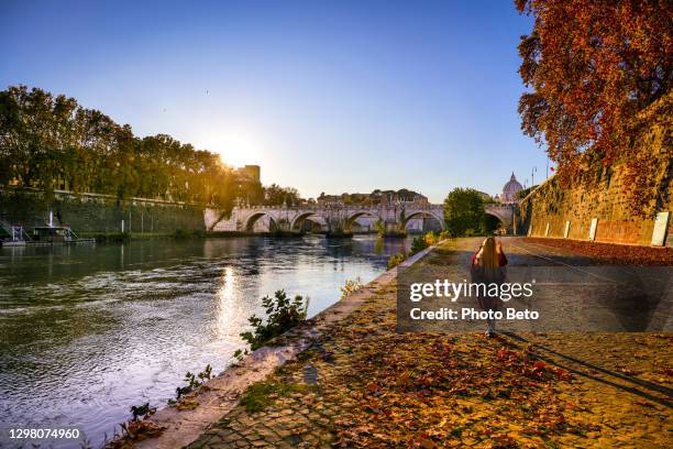 ein warmer herbstsonnenuntergang erhellt das tiber-flussufer in der innenstadt von rom - stadt personen rom herbst stock-fotos und bilder