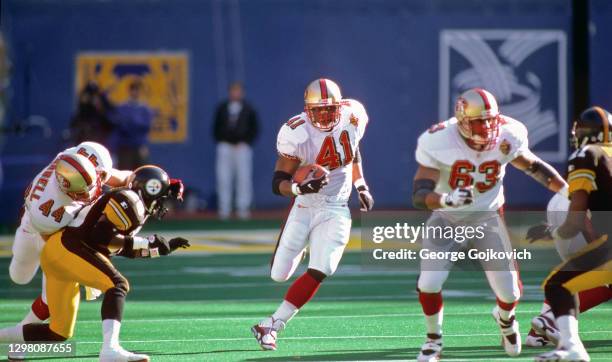 Running back Terry Kirby of the San Francisco 49ers runs with the football as fullback Tommy Vardell and offensive lineman Derrick Deese block during...