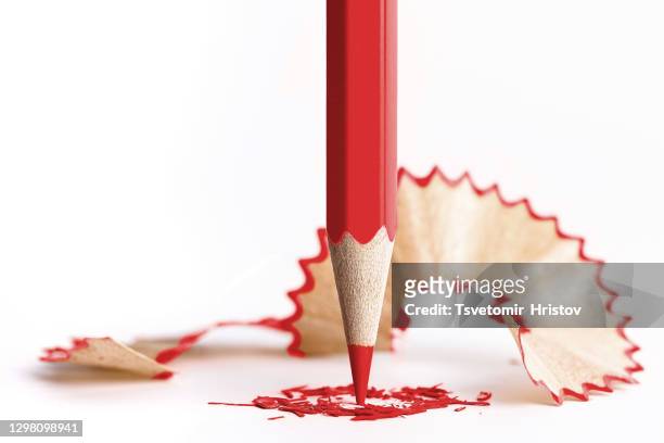 red pencil and shavings on white paper background - scherp stockfoto's en -beelden