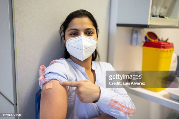 woman proud to have received vaccine - vaccination center stock-fotos und bilder
