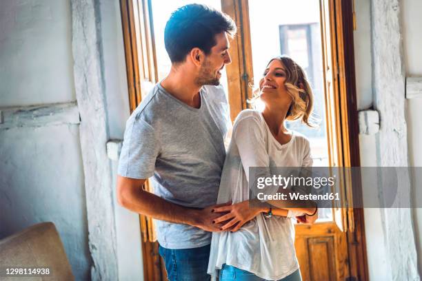 affectionate young couple dancing in living room at home - young couple fotografías e imágenes de stock