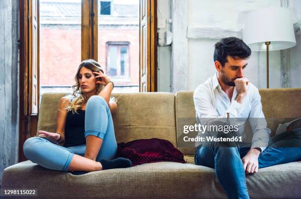 couple sitting on sofa apart and being angry after quarrel - sad woman divorce stock pictures, royalty-free photos & images