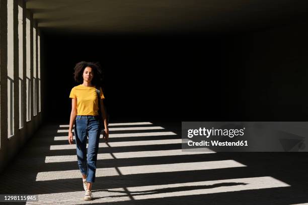 female student walking at university corridor - high contrast stock pictures, royalty-free photos & images