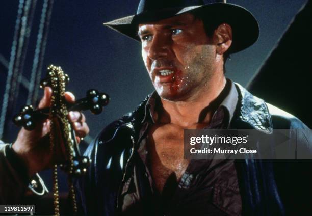 American actor Harrison Ford as the eponymous archaeologist in a scene from the film 'Indiana Jones and the Last Crusade', 1989. Here he traces the...