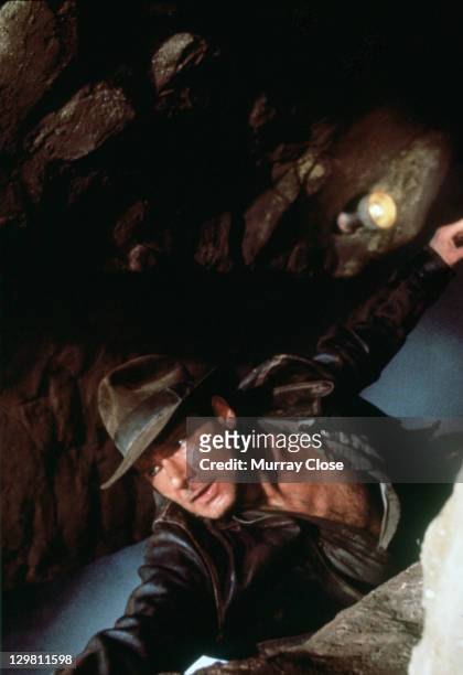 American actor Harrison Ford as the eponymous archaeologist in a scene from the film 'Indiana Jones and the Last Crusade', 1989. Here he hangs from...