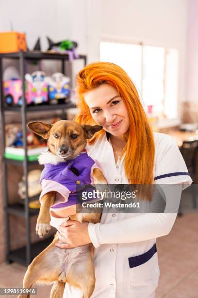 young female nurse carrying dog at rehabilitation center - promises rehab center bildbanksfoton och bilder