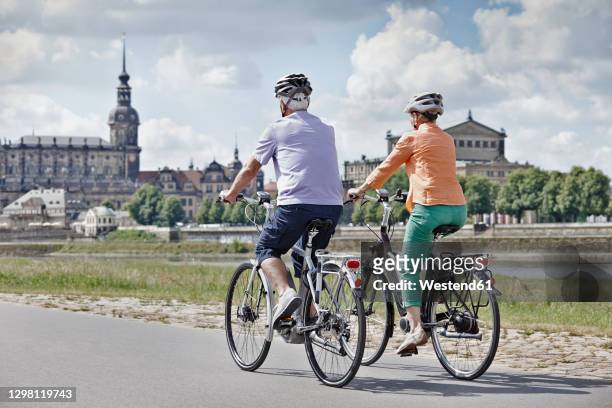 tourist couple riding electric bicycle at semper opera house, dresden, germany - dresden germany fotografías e imágenes de stock
