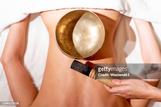 therapist holding mallet by rin gong on female customer's back at health spa - gong stock pictures, royalty-free photos & images