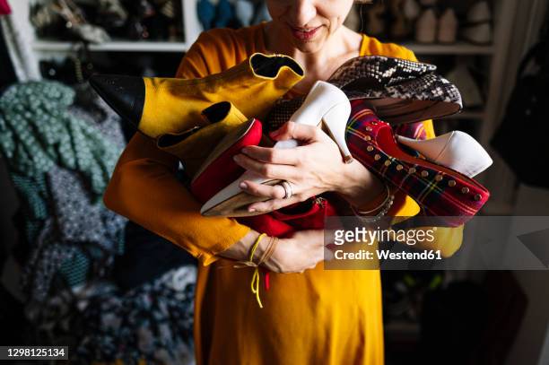 woman carrying variation of shoes in wardrobe at home - large group of objects stock pictures, royalty-free photos & images