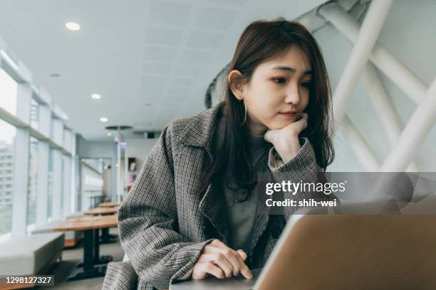 aziatische vrouwelijke student die computer in bibliotheek gebruikt - taiwanese ethnicity stockfoto's en -beelden