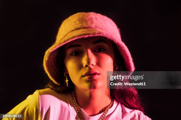 close-up portrait of teenage girl wearing hat against black background - spain teen face bildbanksfoton och bilder