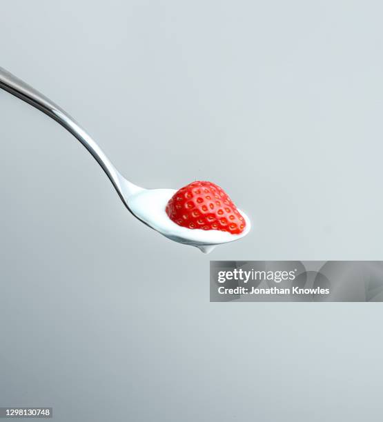 strawberry and yogurt on spoon - yogurt spoon stock-fotos und bilder